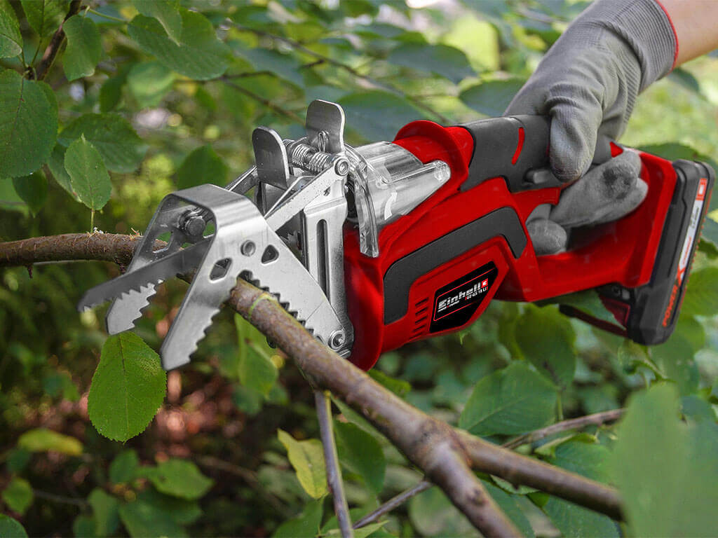 The Einhell cordless pruning saw cutting a branch.