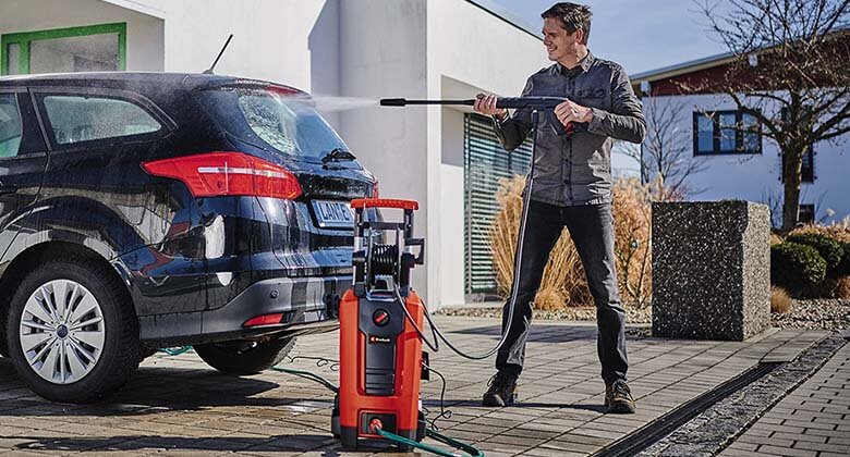 man washing a car with high pressure cleaner